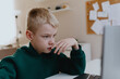 © looking2thesky - A boy with hearing aids focuses intently while playing a game on his laptop, showcasing modern adaptive technology and inclusive digital entertainment for children with hearing disabilities