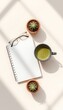 © TORO's STOCK - Daylight streaming over simple objects arranged artistically on a table a notebook, eyeglasses, green beverage, and tiny potted succulents