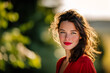 © Kubista - Portrait of Young Woman with Freckles Red Lips and Wavy Dark Brown Hair with Green Bokeh Background