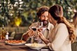 © bnenin - Romantic Couple Enjoying Dinner and Toasting with Wine in an Outdoor Setting