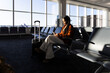 © Westend61 - Businesswoman using smartphone while waiting in airport terminal