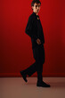 © Bliss - Stylish man poses gracefully against a vibrant red backdrop showcasing modern elegance and fashion
