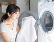 © toriko - 洗濯機からタオルを取り出す女性