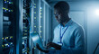 © ekhtiar - Focused IT professional maintaining server network with laptop in a modern data center, ensuring optimal performance and security in a vibrant, high-tech environment