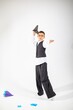 © Anastasia Visuals - A young boy of Middle Eastern descent, dressed in a stylish suit, joyfully throwing a paper airplane in a bright setting.