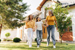 © Maria Vitkovska - Happy family walking together in front of house beautiful mother grandmother and little girl