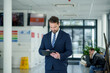 © Halfpoint - Business professional standing with tablet in hand, ready for presentation