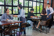 © Rakchanok - Restaurant small business senior couple owners taking food order from customers using digital tablet technology, teamwork service table, Asian husband and wife management professional support