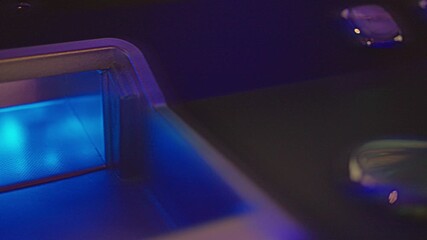 A detailed closeup view of a vibrant gaming machine control panel featuring colorful buttons and bright lights. Casino