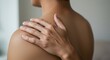 © ARI - Person gently touching their shoulder, experiencing discomfort or tension.