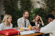 © qunica.com - A diverse group of business professionals discusses work at an outdoor meeting with documents.
