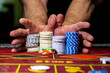© NastyaPhoto - A player playing in a casino raises bets with chips. Gaming business. A player playing in a casino raises the bet with chips. Gaming business.