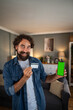 © Migma_Agency - Smiling man holding credit card and smartphone with green screen