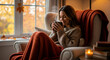 © W.O.W - Woman enjoying hot beverage in cozy armchair, autumn season warmth concept. Relaxing at home during fall.