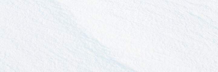 Wall Mural - Wide panoramic winter background with snowy ground. Natural snow texture. Wind sculpted patterns on snow surface.