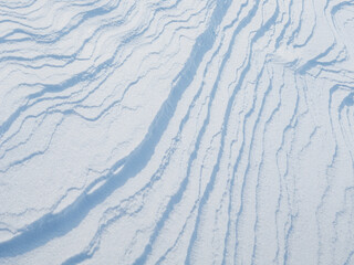Wall Mural - Beautiful winter background with snowy ground. Natural snow texture. Wind sculpted patterns on snow surface. Arctic, Polar region.