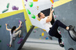 © JackF - Man climbs steep artificial wall in sports complex and trains endurance and muscle strength. Active recreation in fitness center gym, modern types of recreation