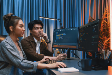 IT developers discussing with point to intelligent website development coder system running data online two screens information technology at neon light room at modern office. Infobahn.