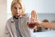 © Pixel-Shot - Mature woman rejecting suggested glass of alcohol. Concept of healthy lifestyle