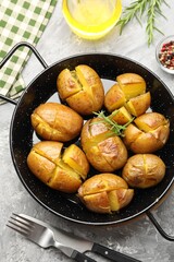 Wall Mural - Tasty baked potatoes with rosemary served on light grey table, flat lay