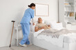 © Pixel-Shot - Female caregiver adjusting happy senior woman's pillow in bedroom