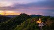 Aerial view of A radiant sunset fills the sky with golden and orange hues above Khao Rang viewpoint,  highlighting the natural contours of the hills and the quiet charm of the urban landscape below.