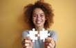 © happy - A woman is holding two puzzle pieces in her hands and smiling. High quality