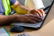 © South Pixels - Close up of male worker using a laptop wearing a safety vest.