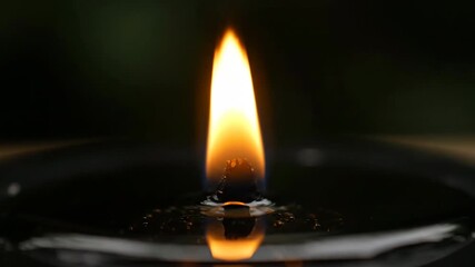 Sticker - a small, controlled flame burns steadily on a dark surface, symbolizing focus and determination burn