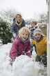© Vato - joyful scene of mother smiling and waving from window as her children play in snow pile outside