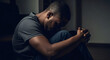 © W.O.W - Depressed african american man sitting alone. Concept of stress, sadness, mental health issue. Emotional struggle and feeling hopeless.