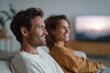 © SolaruS - Happy couple relaxing together, watching a movie at home. Contentment and leisure concept. Ideal for home entertainment, relationship, or lifestyle content.