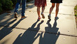 © Vladimir - The long shadows of a group of friends walking together on pavement on a sidewalk in the late afternoon sun