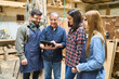 © Robert Kneschke - Intergenerational teamwork at a bustling lumberyard workshop