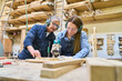© Robert Kneschke - Young apprentice learning woodworking skills with experienced mentor
