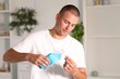 © New Africa - Man with bottle of mouthwash at home