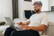 © standret - On the sofa with laptop. Man is in the modern domestic room at home