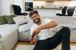 © standret - Front view, playing video games on console using controller. Man is in the modern domestic room at home