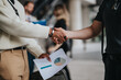 © qunica.com - A close-up of a handshake between two business people in a professional environment, focusing on collaboration and teamwork amidst a modern workspace.