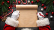 © rafe - Santa claus hands writing on a scroll with christmas decorations candy canes and pine branches on a wooden table