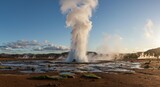 Majestic geyser erupts with powerful steam against a vibrant sunset sky