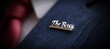 © Alberto Masnovo - Extreme close-up of a lapel pin on a blue suit of an unrecognizable businessman with the words “The Boss” written on it in silver letters. Generative Ai.