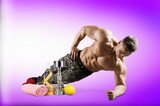 Handsome young sporty muscular man training in gym