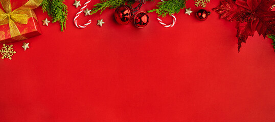 Wall Mural - christmas frame with gift box, fir branches, red baubles, candy canes, golden stars, and poinsettia 