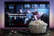 © FonoMariaC - Video streaming app on tv screen behind a bowl of popcorn and a remote control.