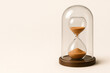 © Olena - An hourglass pouring sand on a wooden stand. Space for text.