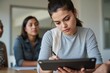 © Abdullah - Close-up portrait of a young Latina businesswoman taking notes on a digital tablet with colleagues networking in background
