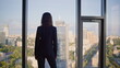 © stockbusters - Successful manager contemplating cityscape from office panoramic window.