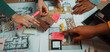 © InfiniteFlow - A vibrant and engaging scene of diverse hands actively collaborating in a design session, showcasing floor plans, colorful swatches, and material samples. SACTR
