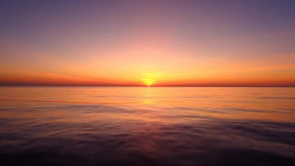 Wall Mural - glorious timelapse capturing a vibrant sunrise painting the tranquil surface of a calm ocean with wa